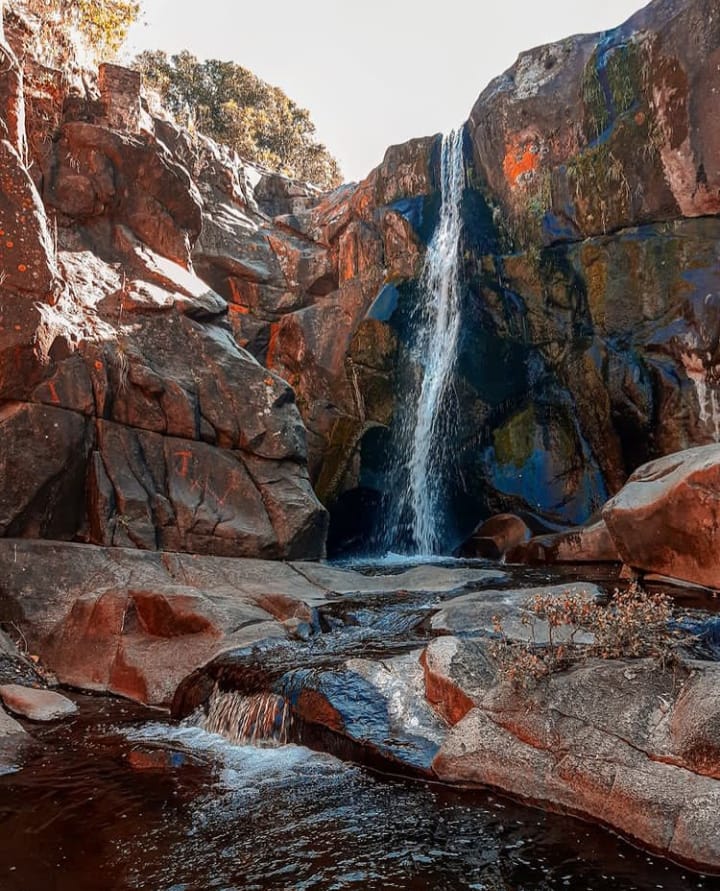 Cascada entre rocas rojizas